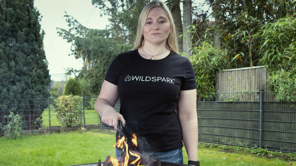 Maja grillt gerade und trägt ein nachhaltiges T-Shirt aus der Wildspark Classic Collection.