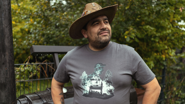 Hawk posiert vor einem Offset-Smoker aus den USA. Er trägt das Wildspark Wildfire Griller Shirt.