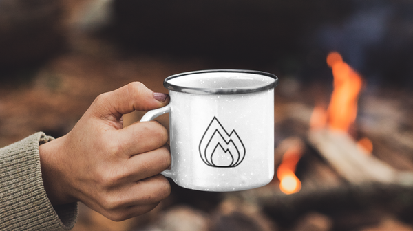 Outdoor Tasse aus Emaille am Lagerfeuer mit Wildspark Logo