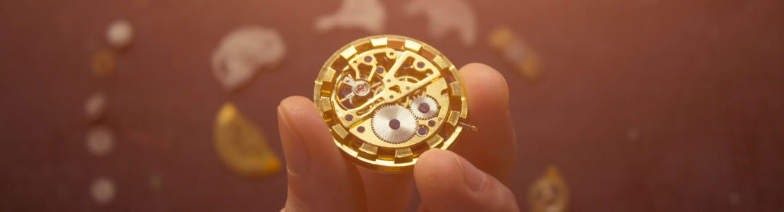 Hand holding a watch movement