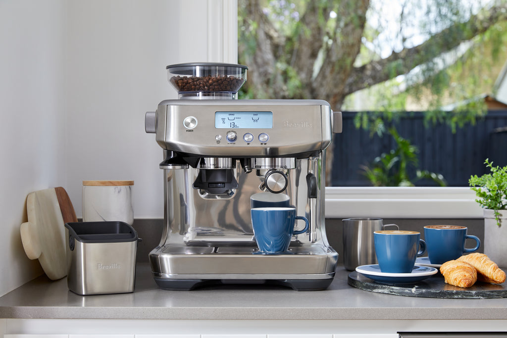 breville barista pro coffee machine bes878bss on a benchtop with blue mugs