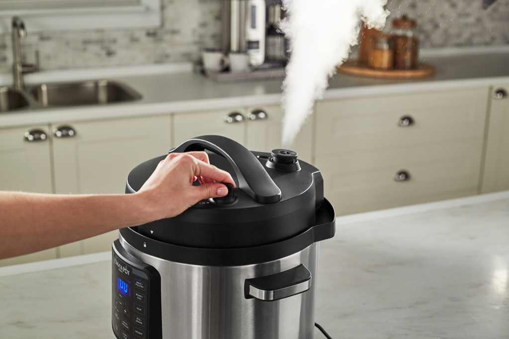 A CrockPot pressure cooker with the pressure being released