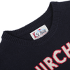 A close-up of the Navy Blue Wool Cashmere Courchevel Sweater from MC2 Saint Barth features red and white text on the front. The collar showcases the "St. Barth" label, infusing your winter wardrobe with a hint of Courchevel chic.