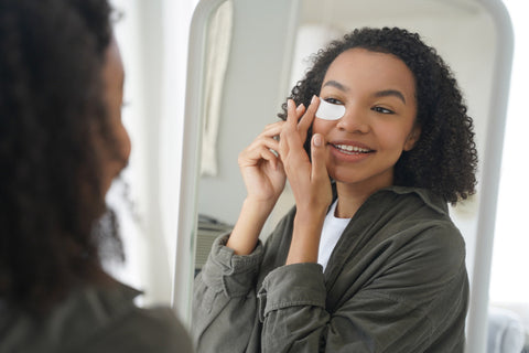 Woman placing eye-patch in her skincare routine in the article Skincare FAQs
