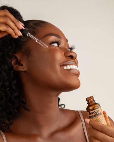 Model holding vitamin C serum to demonstrate how to layer niacinamide and vitamin C serum