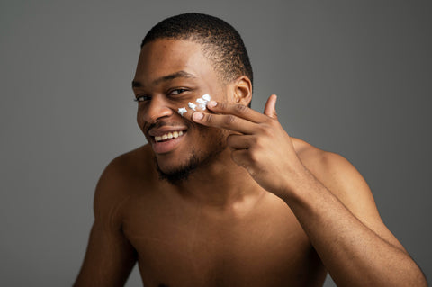Black man applying face cream for a clear and radiant skin.
