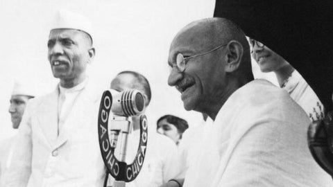 Mahatma Gandhi speaking with microphone