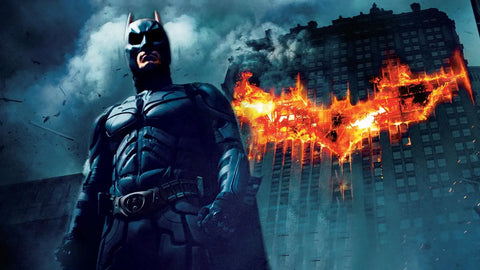 The dark knight poster, batman posing in front of building with burning bat symbol