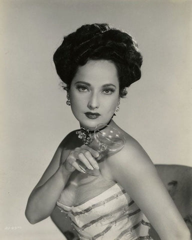 Merle oberon holding a glass