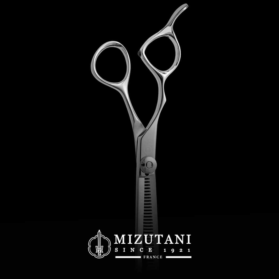 Professional hairdressing scissors on a black background.