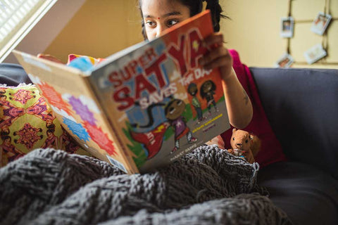 Girl reading Super Satya Saves the Day