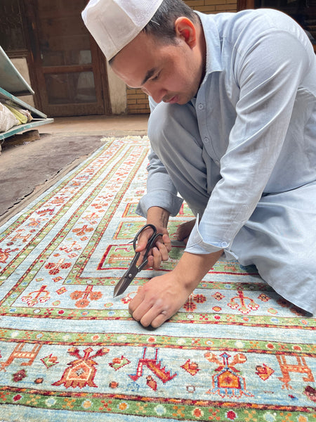A craftsperson working on an Oriental rug