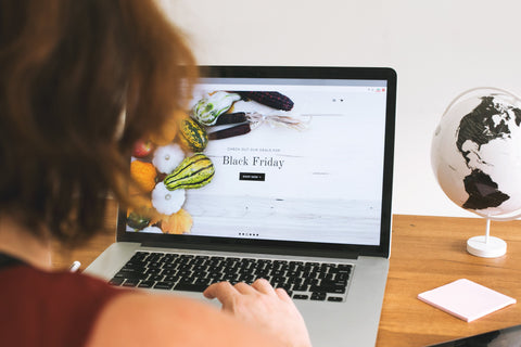 person looking at laptop on desk searching for black Friday sales