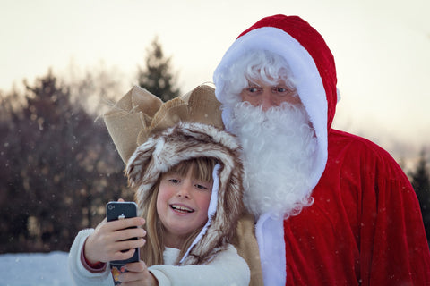 little girl taking a selfie with santa