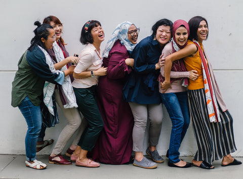 group of women laughing while standing in line