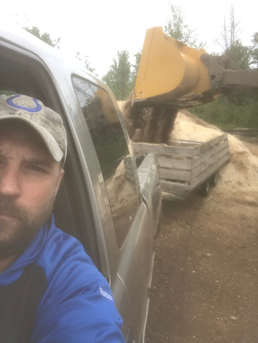 Front end loader dumping sawdust into my trailer for a Mushroom Food Plot from my local sawmill.