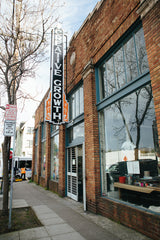 The front of an urban building with large windows with a tall sign that says Creative Growth
