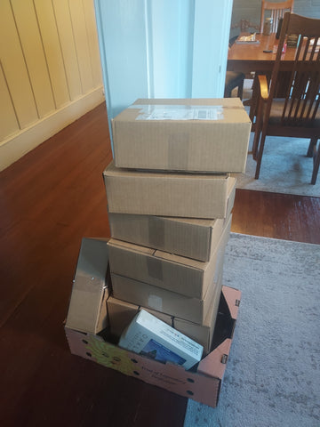 Tall stack of shipping boxes ready to go to the post office.