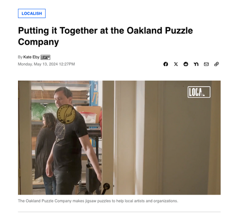 A screenshot of the headline of a news story by Localish with the words "Putting it Together with Oakland Puzzle Company" by Kate Eby and an image of two people walking into a workshop with a door labeled with the Oakland Puzzle Company Logo