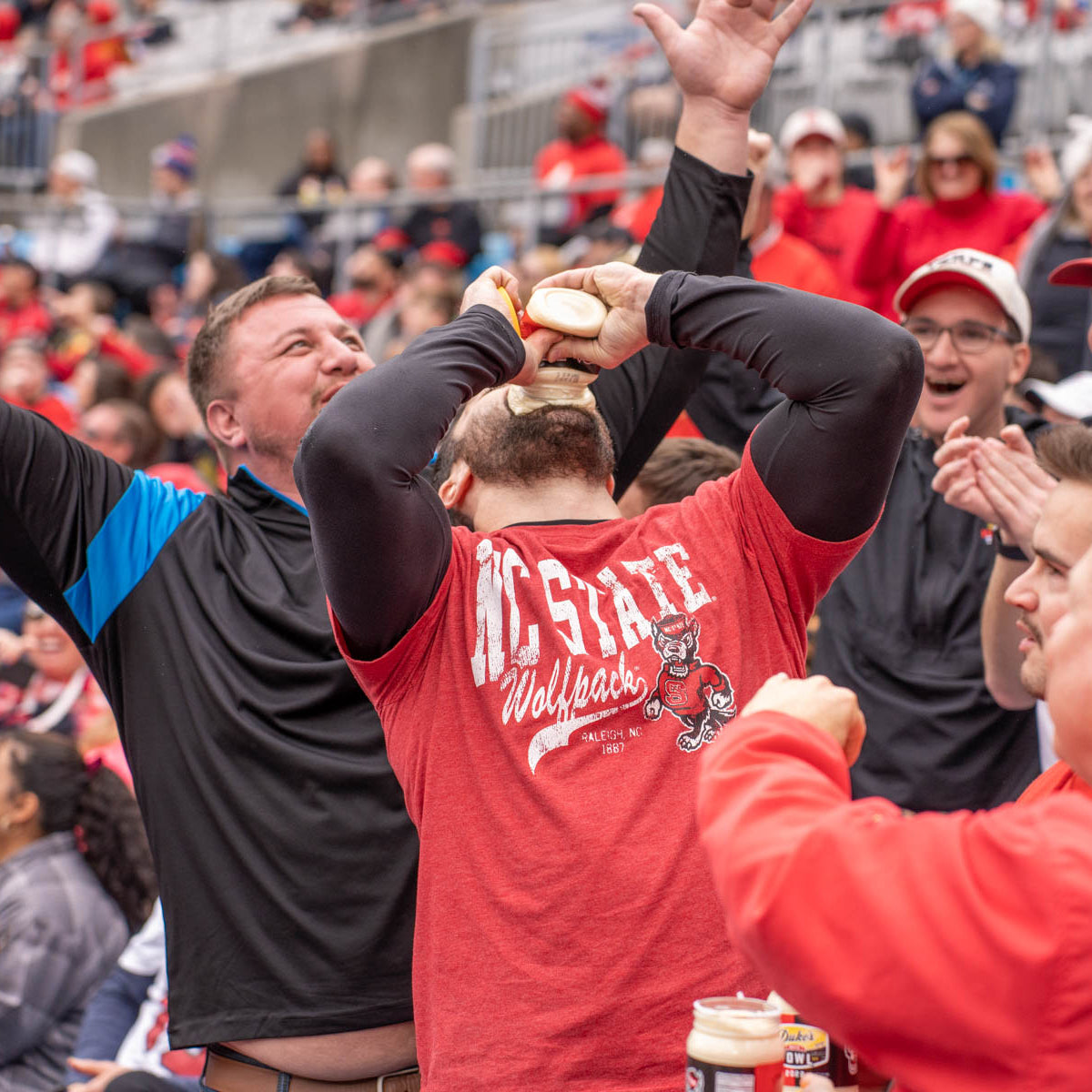 Fans wearing red shirts drinking Mayo from the jar