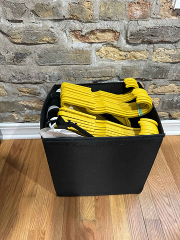 From the REX personal collection - a black storage tub neatly stacked with two piles of hangers both REX and non.