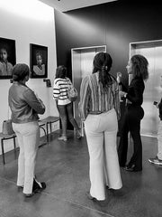 Artist marie de decker showing to visitor artwork made of gold on photography