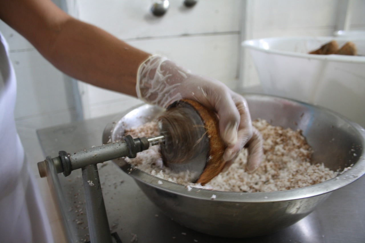 Coconut being skinned by employee.