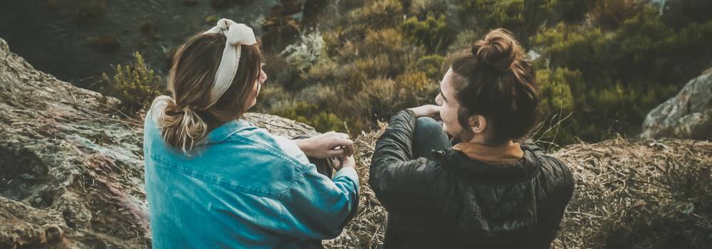 Two young women having a deep conversation in the open outdoors.