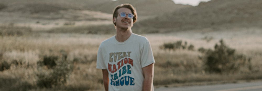 Un homme portant un T-shirt chrétien et souriant de joie.