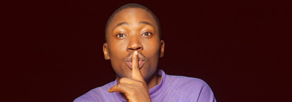 A man holding his finger to his lips as a symbol of silence.