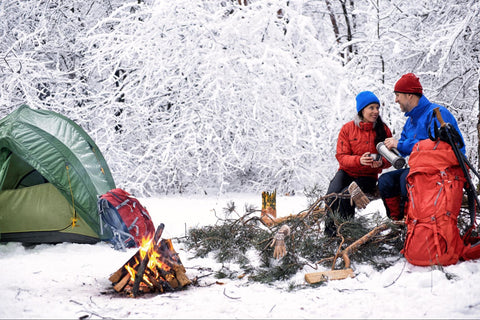 couple sur un feu de camp dans la neige