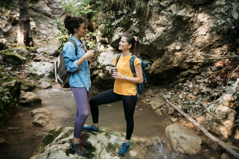 two woman talking while hiking,