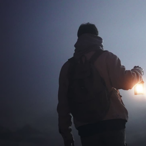 Facing for the unknown young man with the lantern walking at dark foggy night