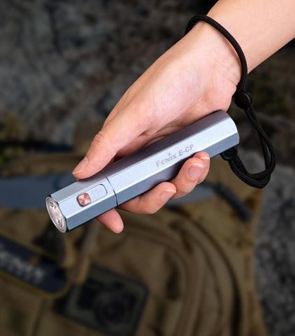 Fenix E-CP Flashlight held in hand with wrist lanyard