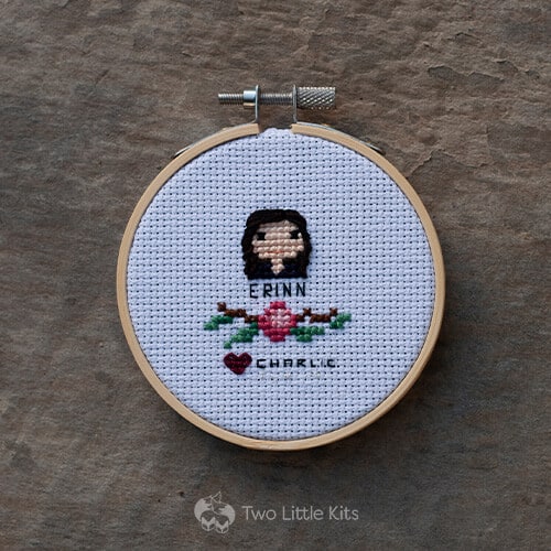 A small cross-stitched "head shot" of a woman with a floral decoration underneath.