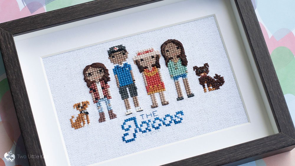 Cross-stitch finished piece: a family portrait of 4 people (Dad, Mum and 2 adult daughters) and their 2 dogs