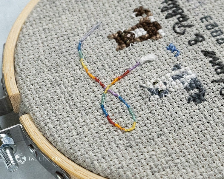 A focus on the rainbow cat toy of the stitched piece.