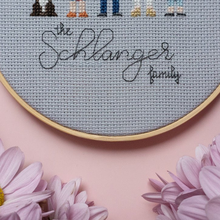 Close-up of backstitching that says "the Schlanger family"