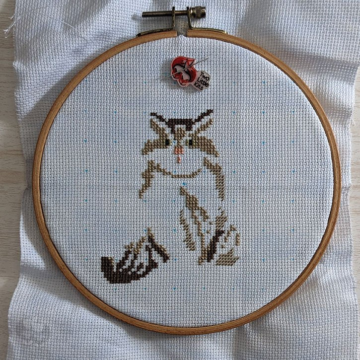 A cross-stitch in its early stage where you can roughly see that it will be a cat