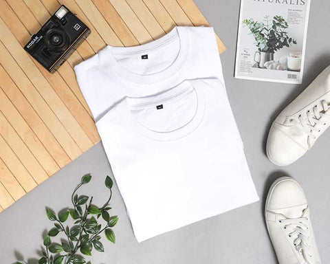 Two plain, folded, crisp-white t-shirts on a lifestyle background. It is the perfect original photo to use as a mockup.