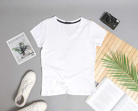A single crisp-white t-shirt laid semi-flat on a lifestyle background. It is the perfect original photo to use as a mockup.