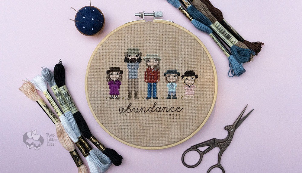 A 6" embroidery hoop with 5 people as "stitch people", cross-stitched