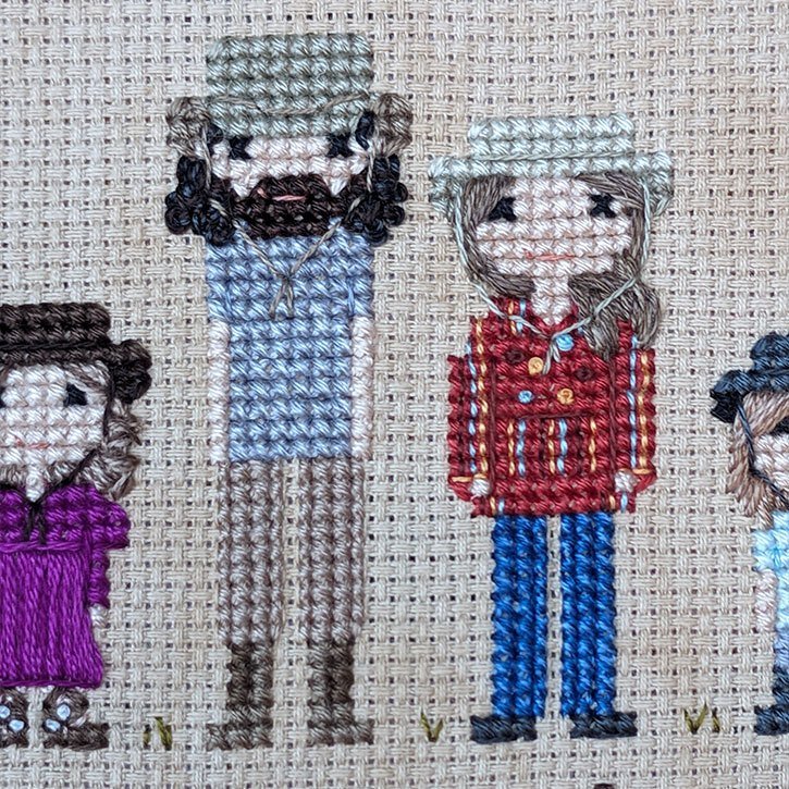 Close-up of a cross-stitch family portrait