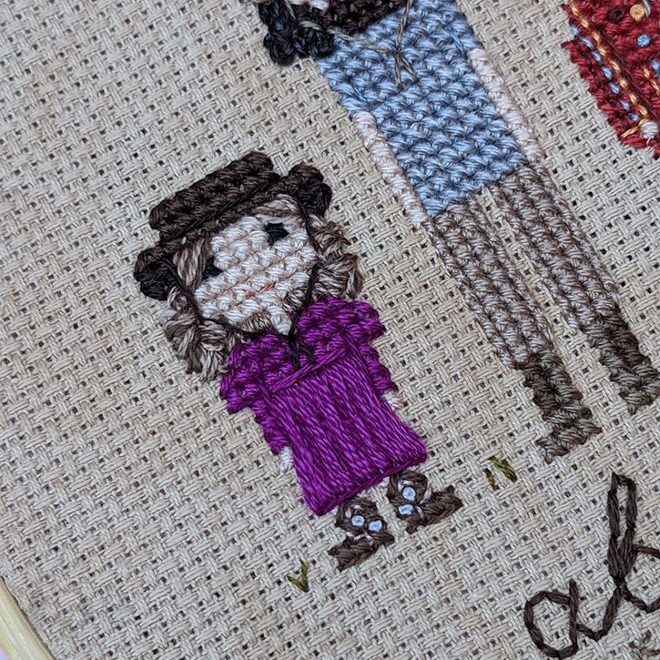 Close-up of a cross-stitch family portrait