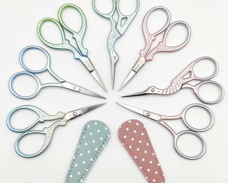 A fan of different styled and differently coloured embroidery scissors