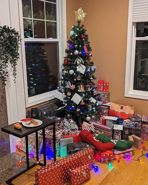 A very decorated Christmas tree with lots of presents underneath it.