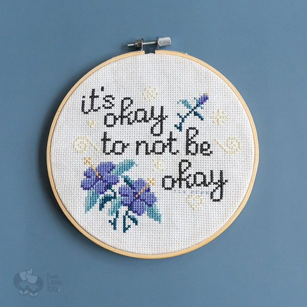 "You Are" cross-stitch pattern, stitched up in an embroidery hoop on a blue background