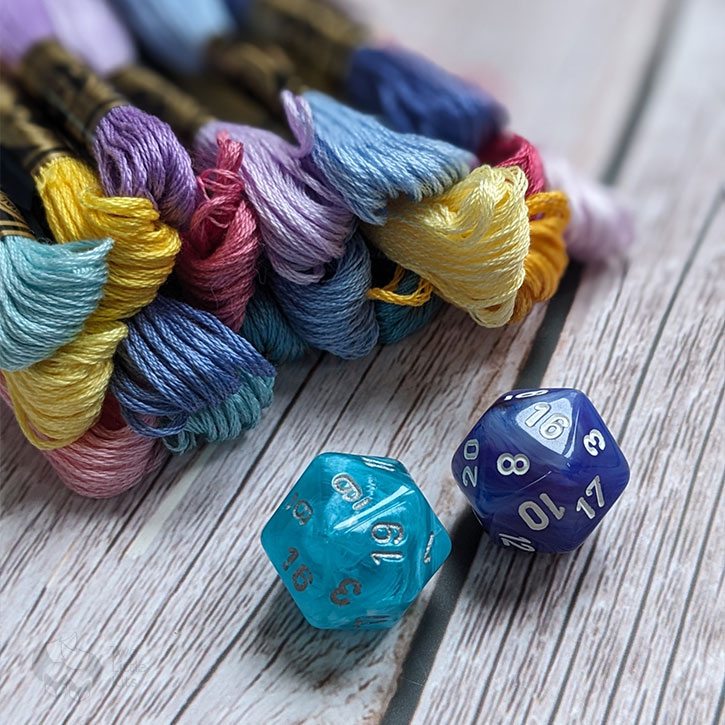 Two D20s (one teal, one a bluey-purple colour) and all 20 of the colours used for the random flowers.