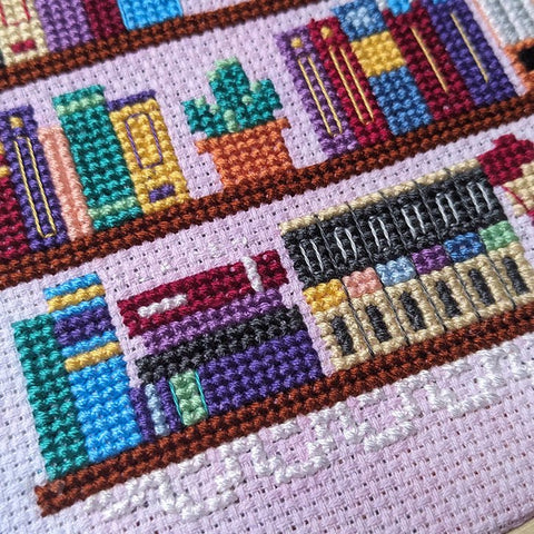 Close-up photograph of the completed cross-stitch bookshelf