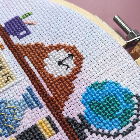 Close-up photograph of the completed cross-stitch bookshelf